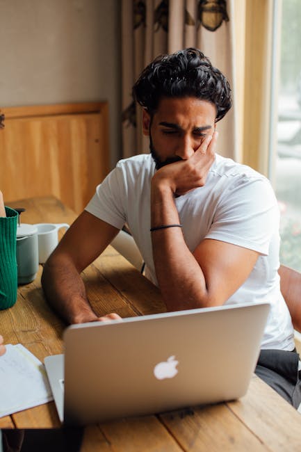 Modern office space with a person thoughtfully looking at their computer screen